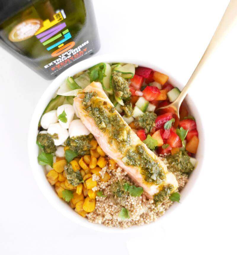 Bowl con pesto y botella condimentando con aceite de oliva extra virgen