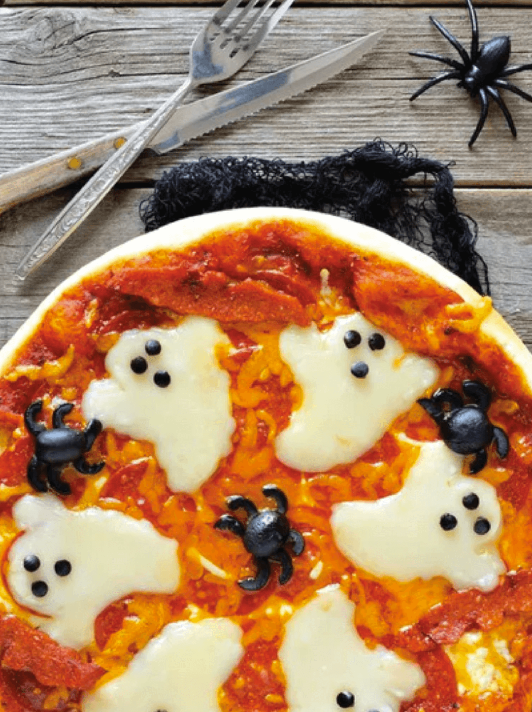 Pizza condimentada con O-Live & Co adornada para Halloween, con el queso con forma de fantasma y las aceitunas a modo de arañas.