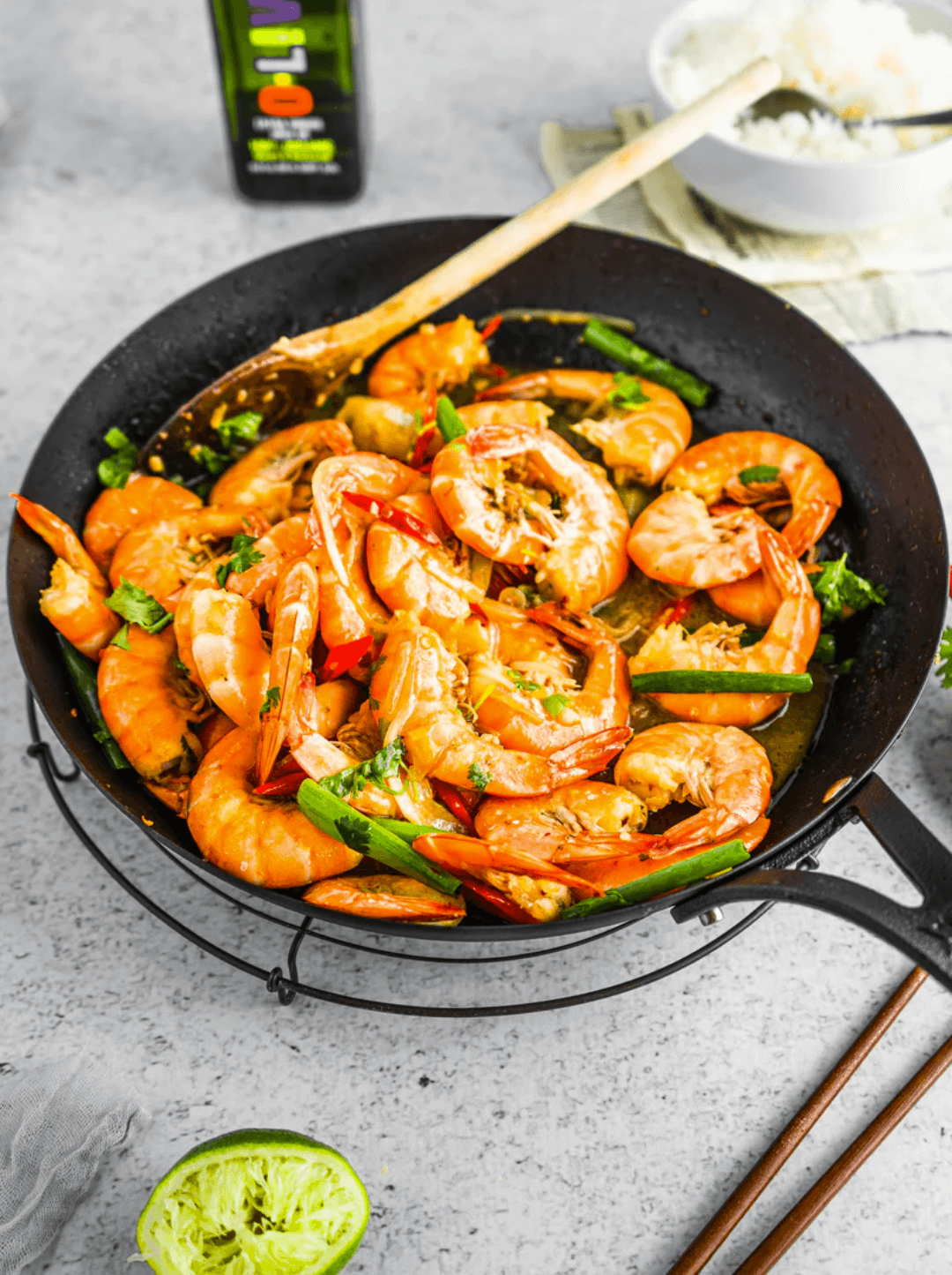 Camarones Caramelizados en un bowl junto a una botella de aceite de oliva O-Live & Co