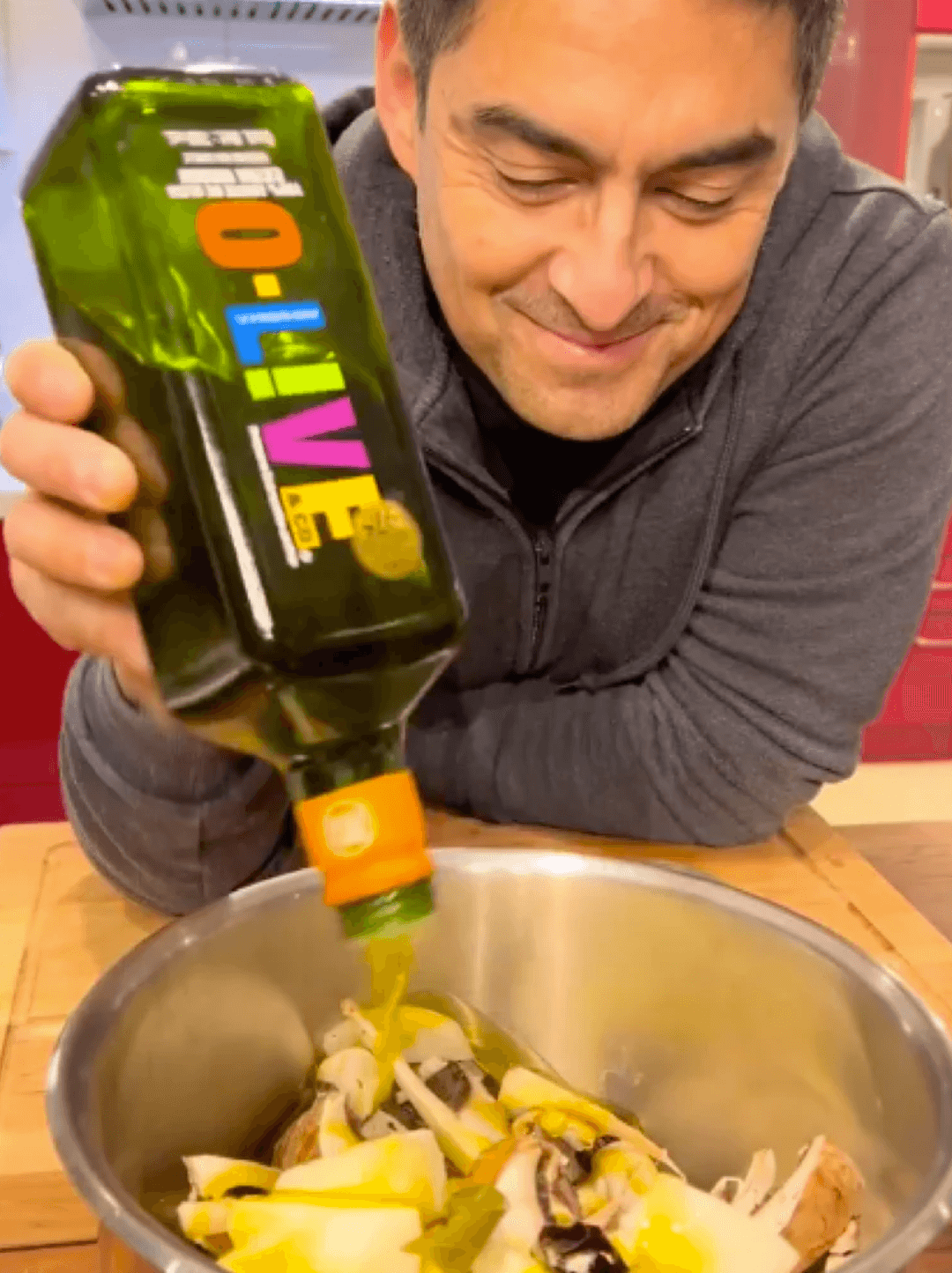 Alvaro Barrientos, cocinero O-Live, agregando aceite de oliva a un recipiente con verduras.