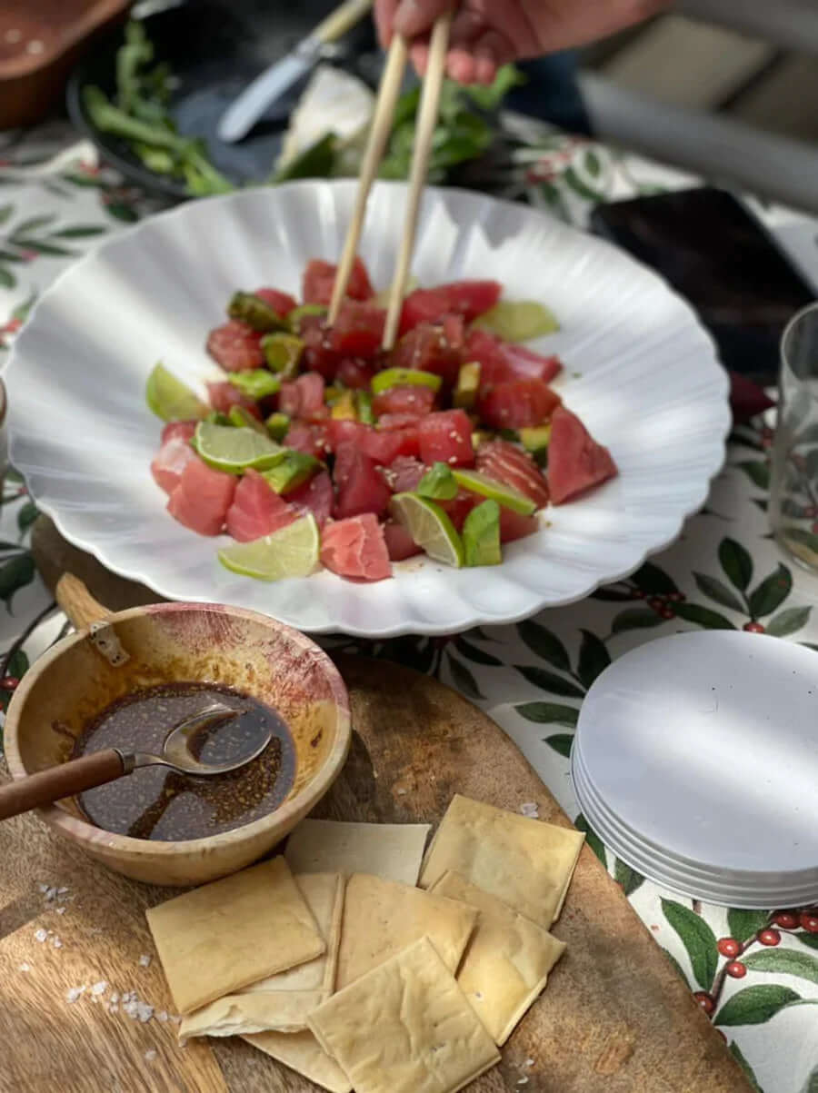Recipiente con atún y limón de pica junto a una salsa y unas bocaditos para untar.