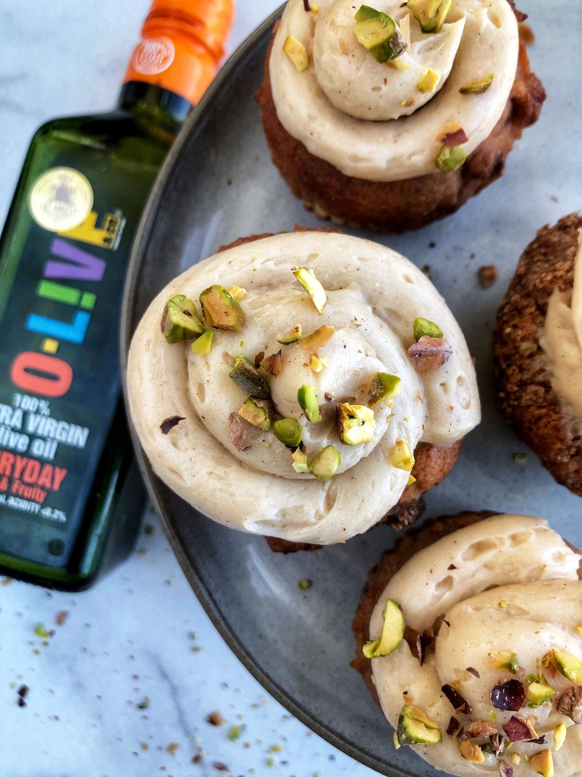 Cupcakes de Pistacho y Maple junto a una botella de aceite de oliva O-Live & Co.
