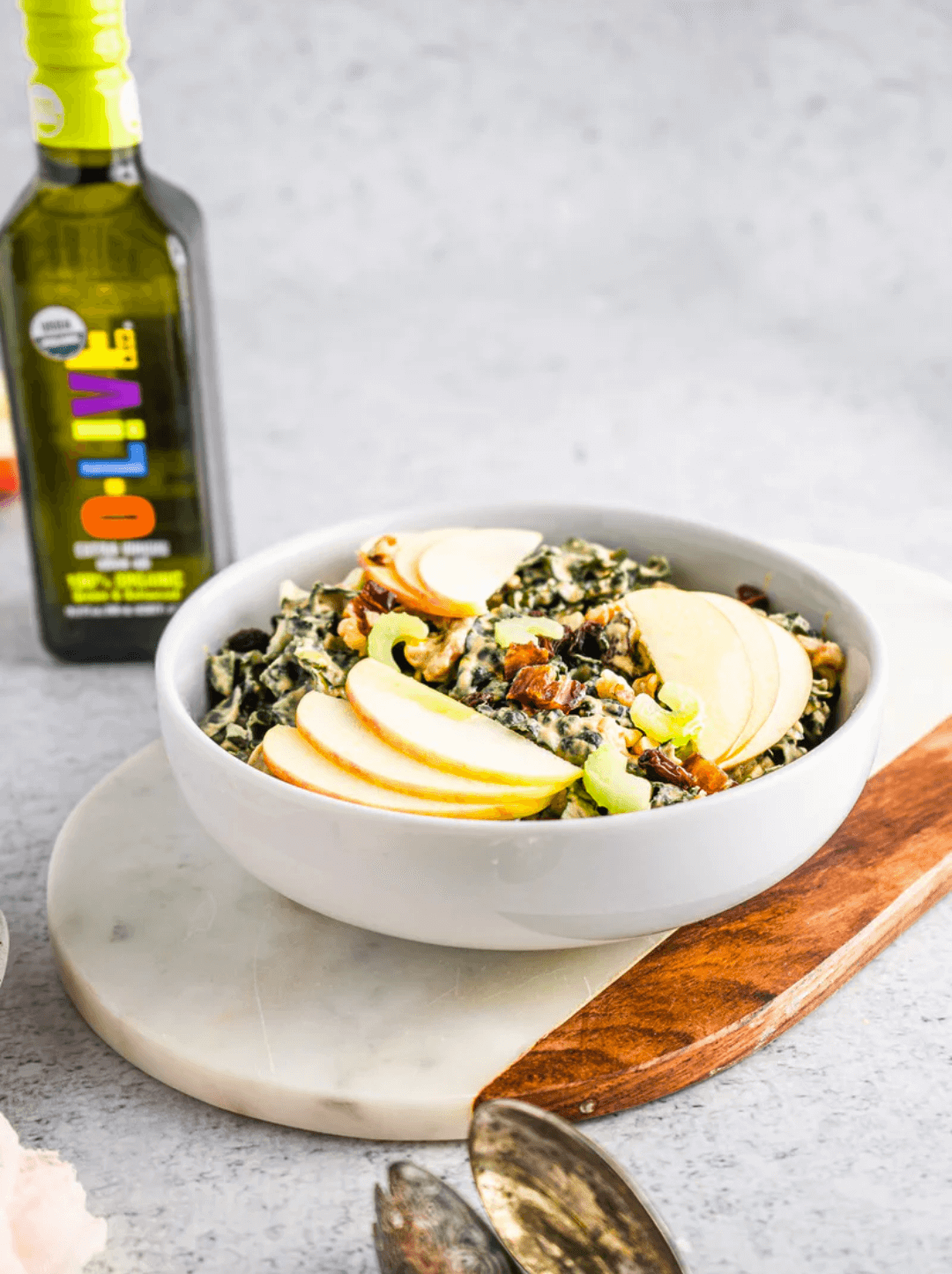 Kale Waldorf Salad acompañado de una botella de aceite de oliva O-Live & Co