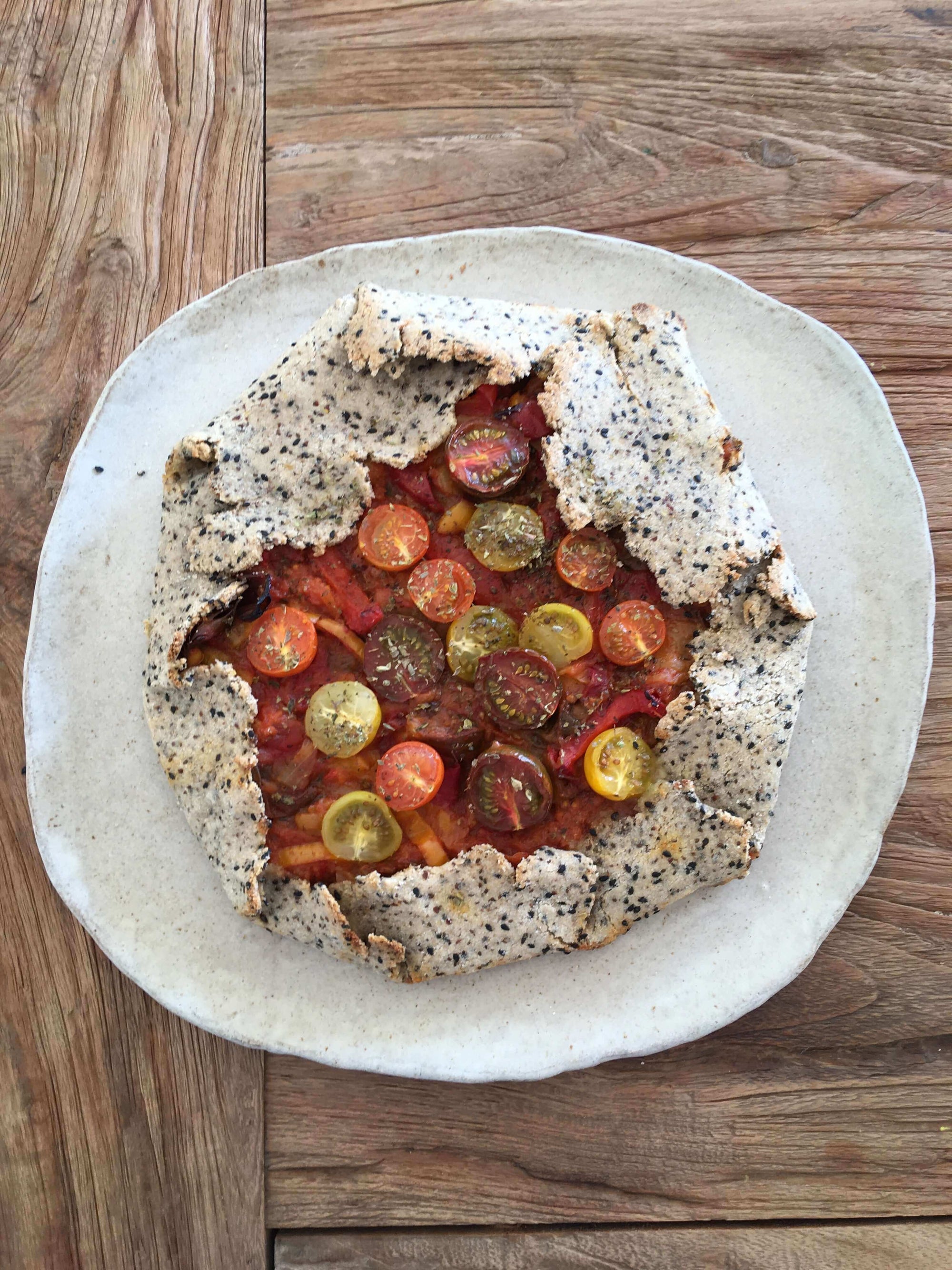 Tartaleta de verduras y tomates cherry servidos en un plato blanco
