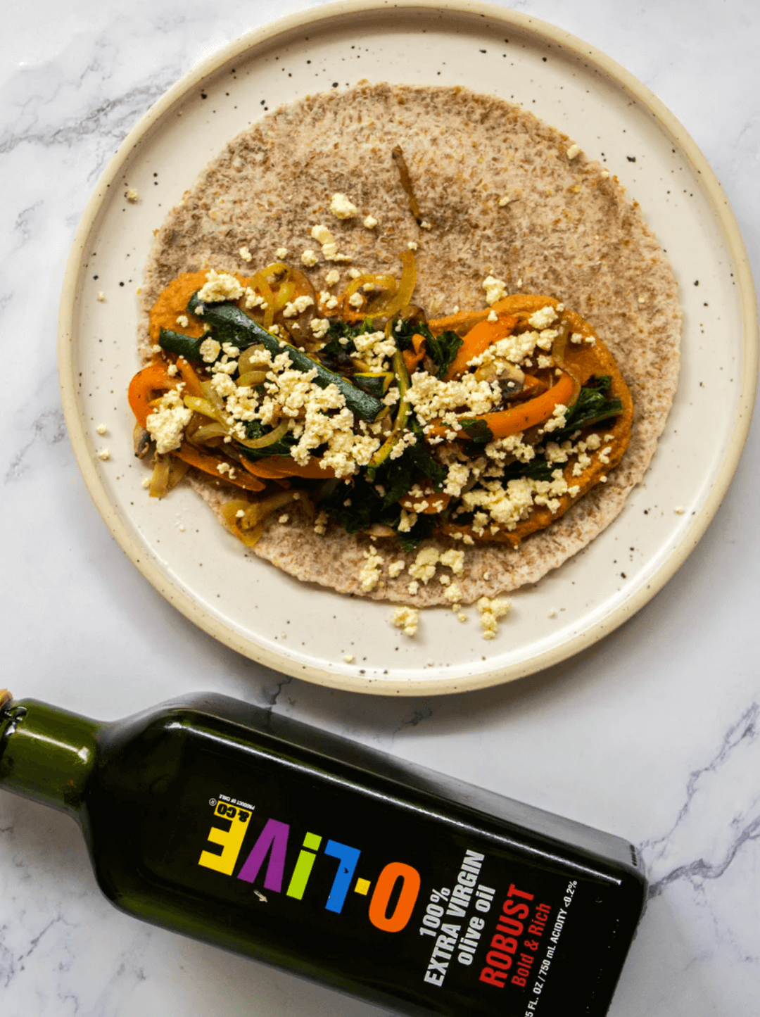 Plato de Hummus de tomate deshidratado acompañado de una botella de aceite de oliva O-Live & Co