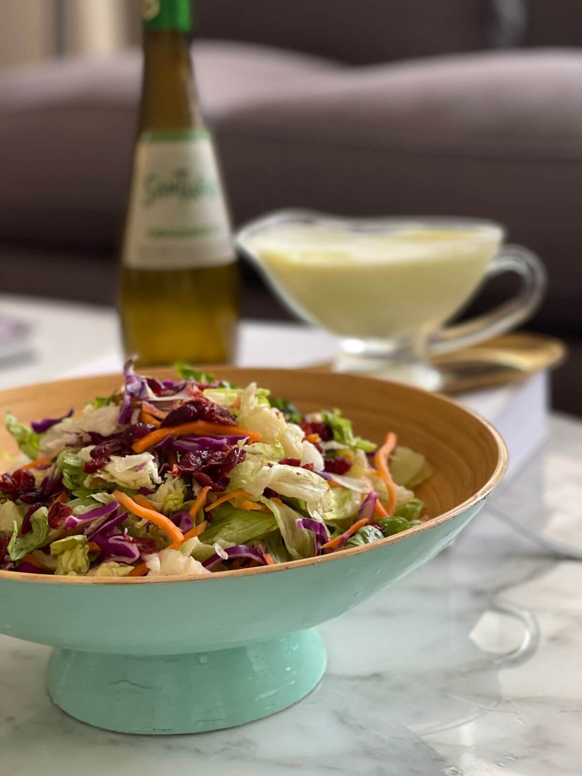 Recipiente con ensalada y de fondo la lactonesa junto a la botella de aceite de oliva Santiago Premium.