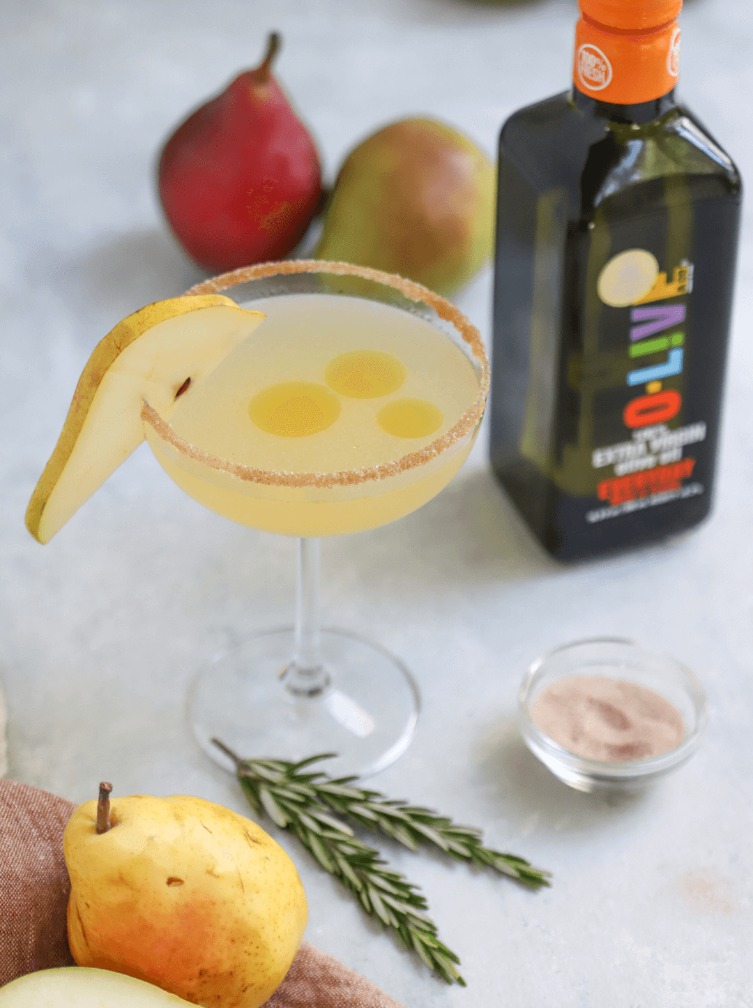 Cóctel de Pera junto a una botella de aceite de oliva O-Live & Co.