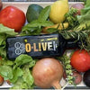 Botella de aceto O-Live&Co entre frutas y verduras 