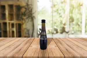 Botella de 250 ml de Aceto Santiago sobre mesa de madera